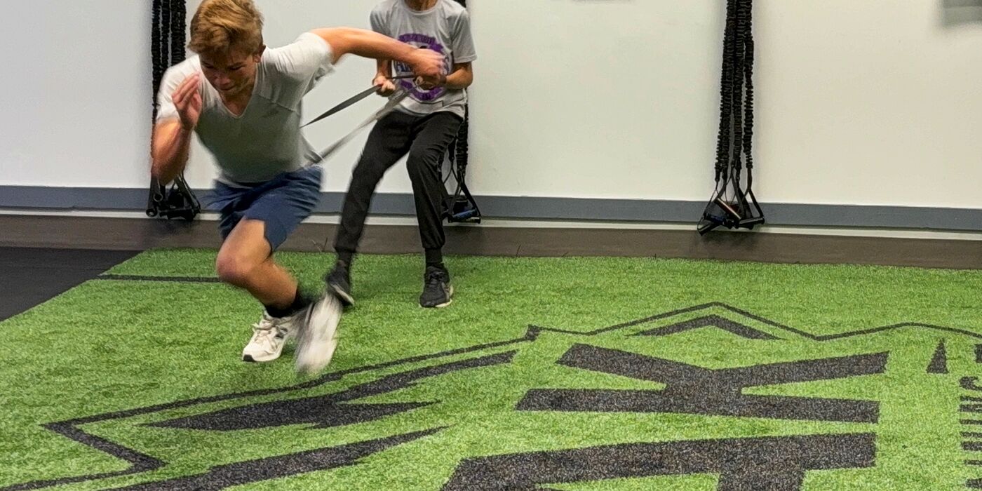 Athlete driving forward against a resistance band
