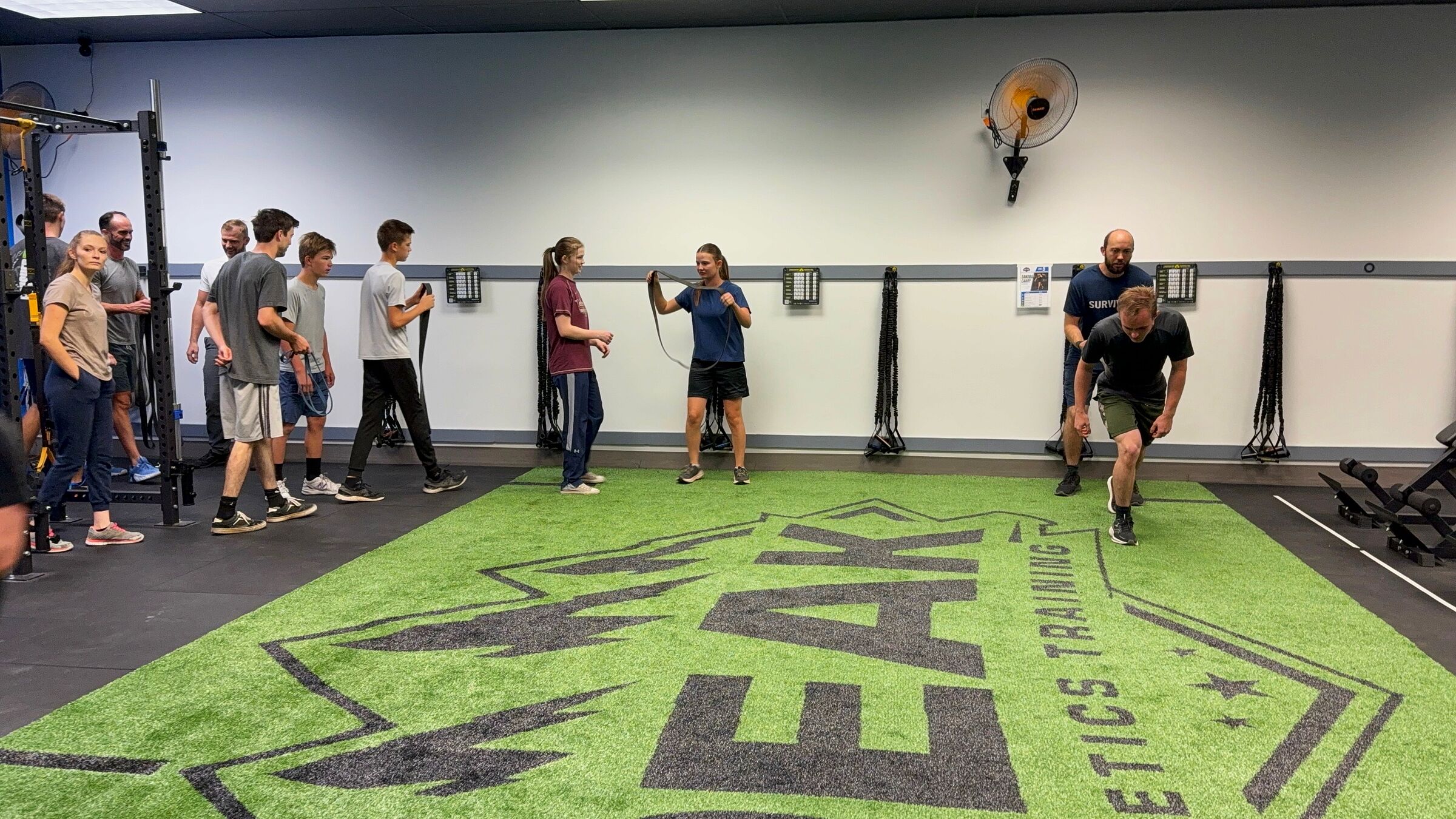 PEAK athletes running a band sprint drill on the PEAK turf