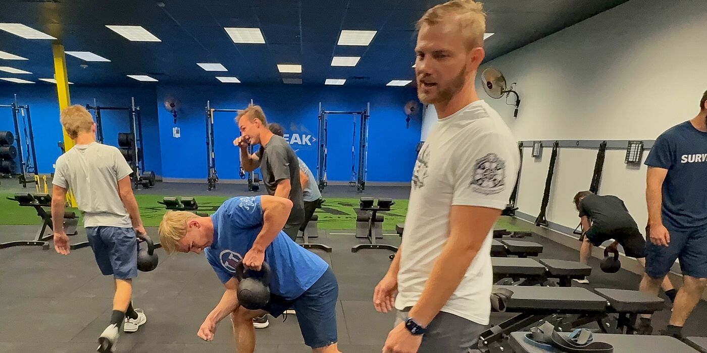 PEAK coach talking athletes through kettlebell rows
