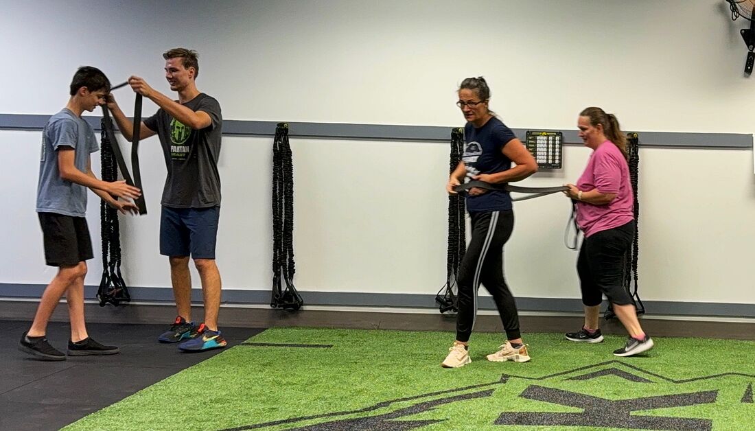 Athletes pairing up for a partner band drill